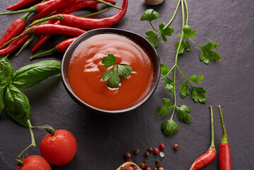 .red hot chilli sauce. tomato ketchup, chilli sauce, puree with chili pepper, Vegetables, tomatoes and garlic. on on black stone background. top view