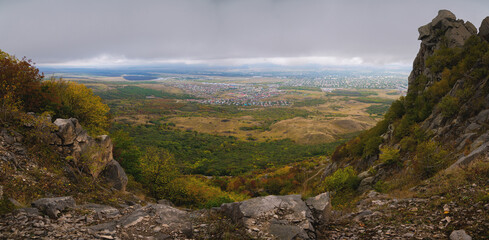 rocky cliff at the foot of the village against a cloudy sky, after or before a thunderstorm, panoramic view