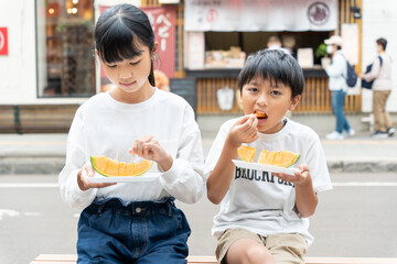 北海道旅行で新鮮なメロンを食べている日本人の子供