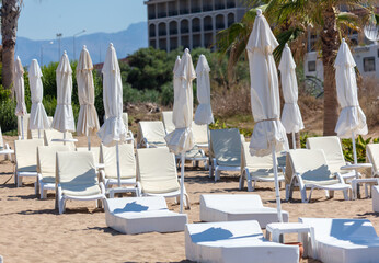 Sunbeds with sun loungers on the beach - obrazy, fototapety, plakaty