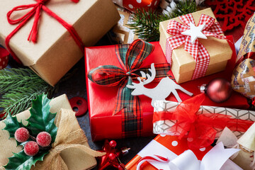 Many different Christmas gifts decorated with beautiful bows, festive seasonal ornaments