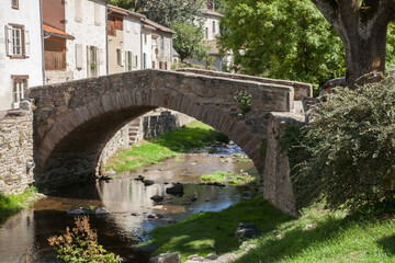 Fototapeta na wymiar Vieux petit pont franchissant la rivière Voireuze au village de Blesles (Haute-Loire)