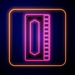 Glowing neon Harmonica icon isolated on black background. Musical instrument. Vector