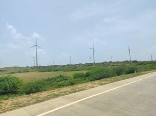 Somnath, Gujarat India- September 22 2022: Windmills placed near the coastal highway to generate clean and green electricity. Energy generation can be done in sustainable way using wind turbines.