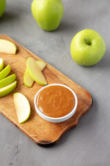 Homemade Caramel Apple Dip on a rustic wooden board, low angle view.