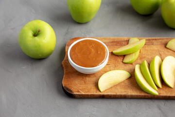 Homemade Caramel Apple Dip on a rustic wooden board, side view.