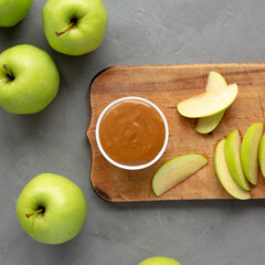 Homemade Caramel Apple Dip on a rustic wooden board on a gray background, top view. Flat lay, overhead, from above.