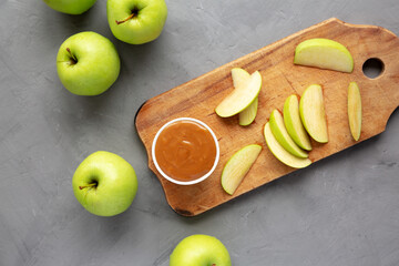 Homemade Caramel Apple Dip on a rustic wooden board, top view. Flat lay, overhead, from above.
