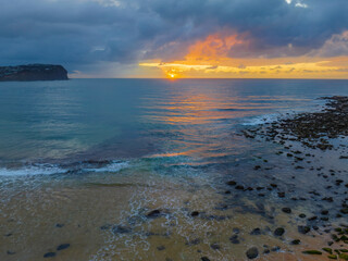 Drizzly moody sunrise seascape with cloud filled sky