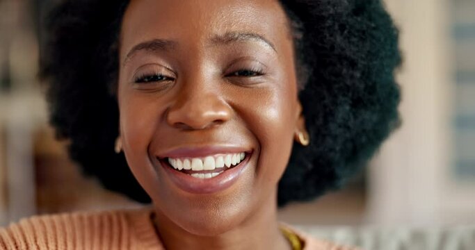 Happy, smile and face portrait of a black woman relaxing on a sofa in the living room of home. Happiness, joy and laugh of a young african female with afro sitting on a couch in a lounge at a house