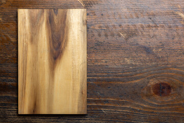 Cutting board on wood kitchen table. Food recipe concept at wood background texture with copy space.