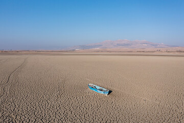 Extreme drought condition on a lake. Abandoned boat is seen at the bottom of a river. Climate change, global warming concept