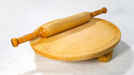 Roti or bread cutting and flatting board with rolling pin for homemade baking on white background.
