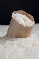 a pile of white rice in a paper bag and on the table