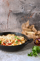 Fototapeta na wymiar pan with pasta with tomato sauce, sardines and parmesan on the table
