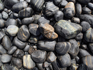 Nature background from black sea stones on the beach.