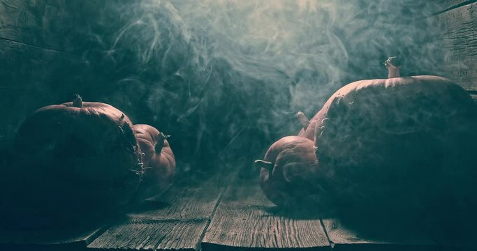 Illuminated and orange Halloween pumpkin with smoke and light.