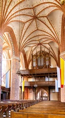 Poster Main nave with organs of historic Holy Mary gothic Kosciol Mariacki church in old town quarter of Trzebiatow in Poland © Art Media Factory