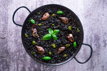 Black paella with squid and pistachio pesto. Tapa paella typical recipe from the Spanish...