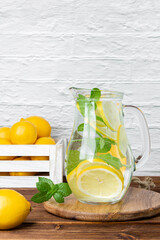 Fototapeta premium Lemonade with mint in jug and lemons in crate