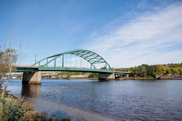Obraz premium Blaydon England: 17th Sept 2022: View of Newcastle upon Tyne's Scotswood Bridge from the Tyne River in Blaydon. Sunny day with blue sky and light clouds