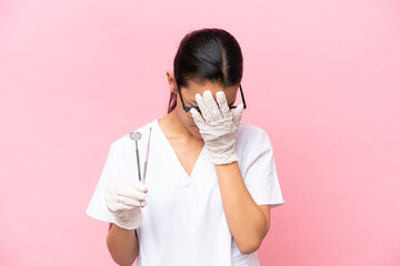 Dentist Colombian woman isolated on pink background with tired and sick expression
