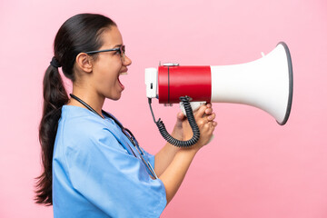 Young nurse Colombian woman isolated on pink background shouting through a megaphone