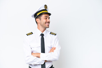 Airplane pilot over isolated white background with arms crossed and happy