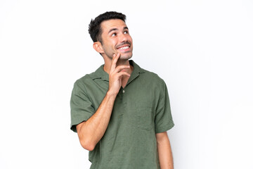 Young handsome man over isolated white background thinking an idea while looking up