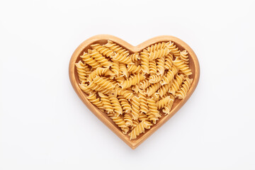 Pasta in a heart shaped wood bowl.