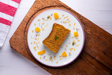 Fototapeta na wymiar Orange sponge cake seen from above decorated with a few slices of fruit.