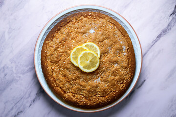Lemon cake seen from above decorated with a few slices of fruit.