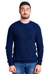 Fototapeta premium Young handsome man wearing casual clothes smiling looking to the side and staring away thinking.
