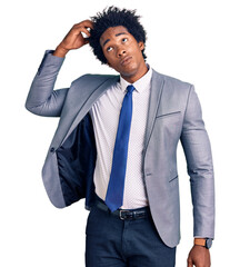 Handsome african american man with afro hair wearing business jacket confuse and wondering about question. uncertain with doubt, thinking with hand on head. pensive concept.