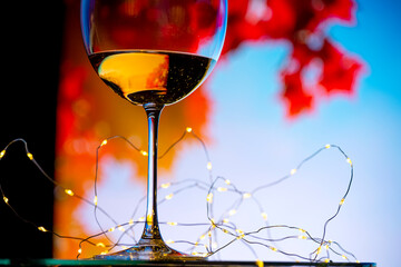 A glass of wine on a window overlooking autumn colorful trees.