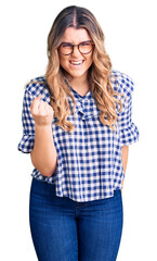 Young caucasian woman wearing casual clothes angry and mad raising fist frustrated and furious while shouting with anger. rage and aggressive concept.