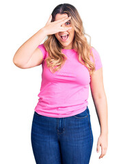 Young caucasian woman wearing sportswear peeking in shock covering face and eyes with hand, looking through fingers with embarrassed expression.