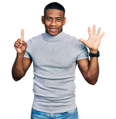 Young black man wearing casual t shirt showing and pointing up with fingers number six while smiling confident and happy.
