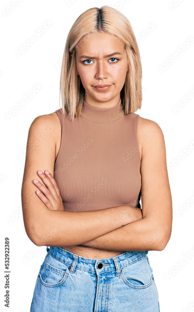 Wall mural Beautiful young blonde woman wearing casual style with sleeveless shirt skeptic and nervous, disapproving expression on face with crossed arms. negative person.