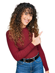 Young hispanic girl wearing casual clothes cheerful with a smile of face pointing with hand and finger up to the side with happy and natural expression on face