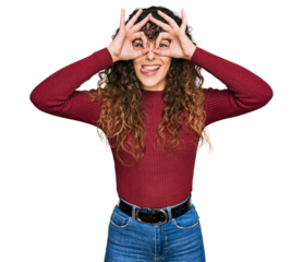 Young hispanic girl wearing casual clothes doing ok gesture like binoculars sticking tongue out, eyes looking through fingers. crazy expression.