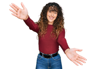 Young hispanic girl wearing casual clothes looking at the camera smiling with open arms for hug. cheerful expression embracing happiness.