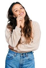 Young hispanic girl wearing casual clothes smiling looking confident at the camera with crossed arms and hand on chin. thinking positive.