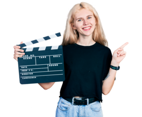 Young caucasian woman holding video film clapboard smiling happy pointing with hand and finger to the side