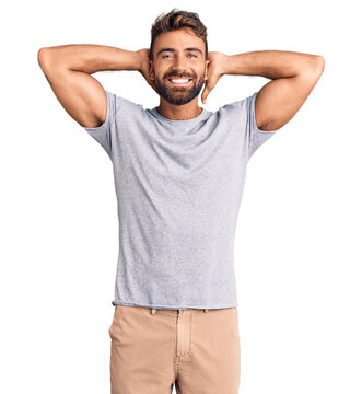 Young hispanic man wearing casual clothes relaxing and stretching, arms and hands behind head and neck smiling happy
