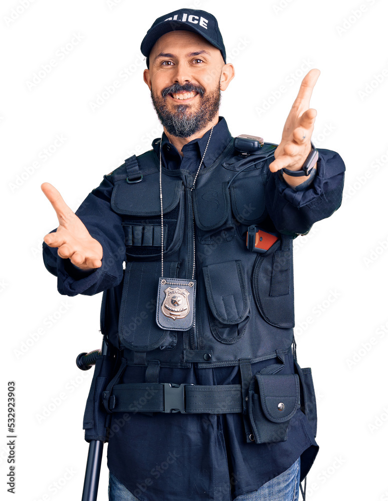 Sticker Young handsome man wearing police uniform looking at the camera smiling with open arms for hug. cheerful expression embracing happiness.