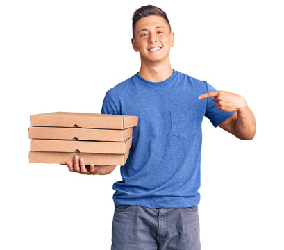 Young handsome hispanic man holding delivery pizza box pointing finger to one self smiling happy and proud