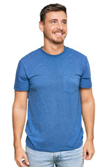 Fototapeta premium Handsome caucasian man wearing casual clothes looking away to side with smile on face, natural expression. laughing confident.
