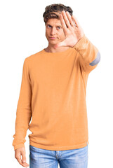 Young handsome man wearing casual clothes doing stop sing with palm of the hand. warning expression with negative and serious gesture on the face.