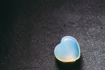 Pierre polie opale welo en forme de coeur sur un fond noir - Minéral naturel